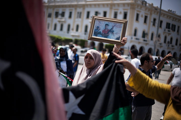 Libya Elections: A Libyan woman holds a framed photograph of a person killed in the uprising