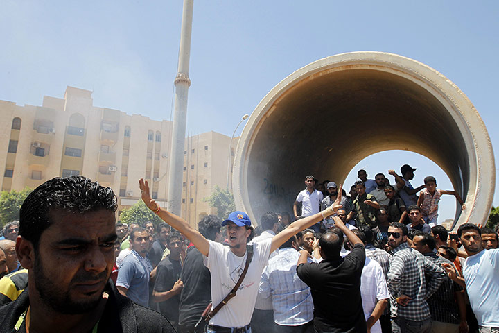 Libya Elections: An armed Libyan protester gestures outside a polling station in Benghazi