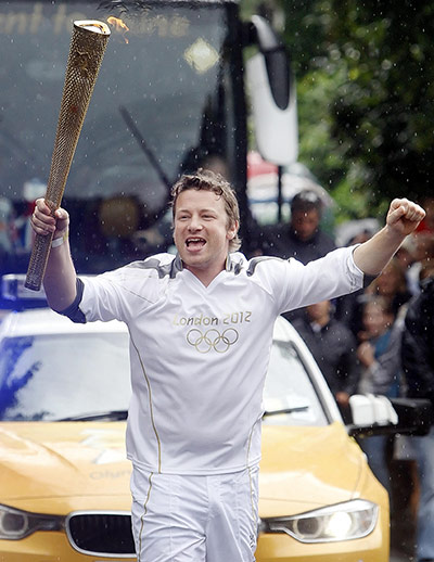 Olympic flame: Torchbearer 063 Jamie Oliver carries the flame between Newport
