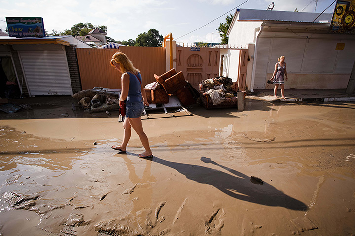 Russia Floods: A woman walks in a muddy street in the Black Sea resort of Gelendzhik