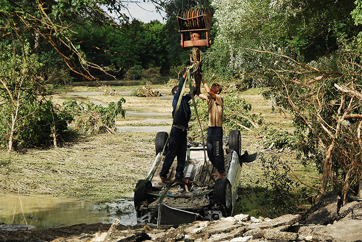 Russia floods: Local residents lift an overturned car in Krymsk