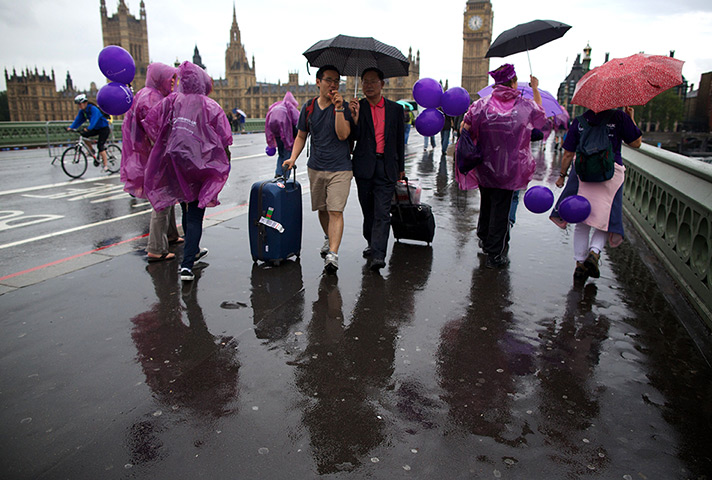 Summer rain: People walk along Westminster Bridge during a rain shower in London