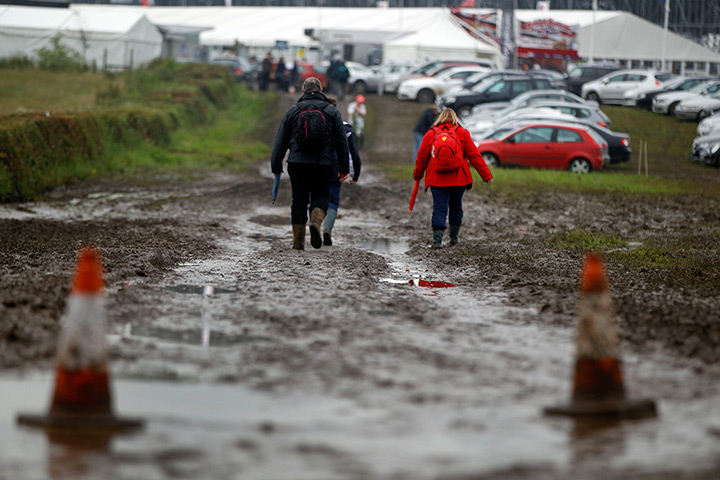 Summer rain: Formula 1 fans walk past puddles on their way to Silverstone circuit