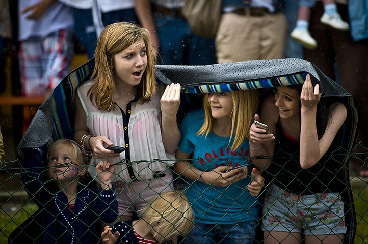 Summer rain: Spectators wait for the Olympic Flame to pass through Newport