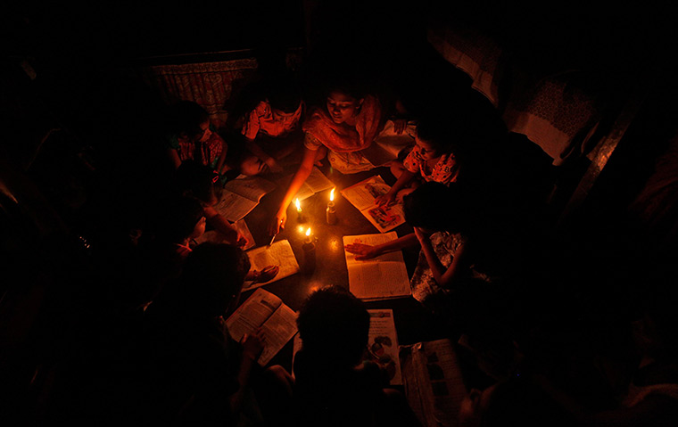 India blackout ends: A teacher conducts a lesson in the light of kerosene lamps