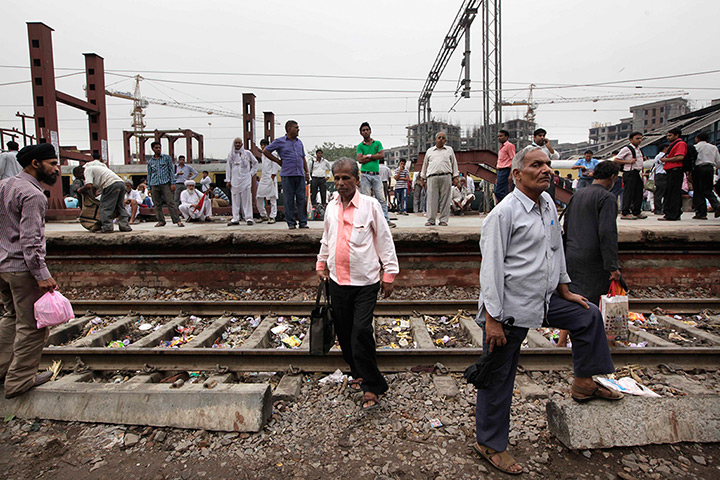 India blackout ends: Stranded passengers wait for train services to resume at a railway station