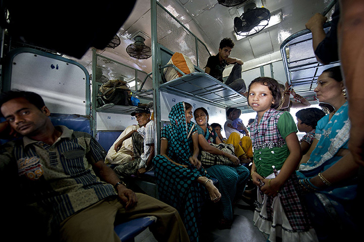 24hours in pictures: Indian passengers wait on a train during a power outage 