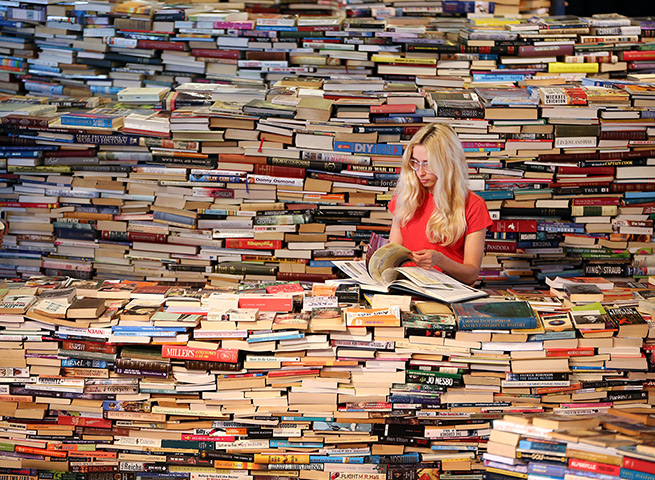 24hours in pictures: Women looks at a book in the aMAZEme labyrinth at The Southbank Centre
