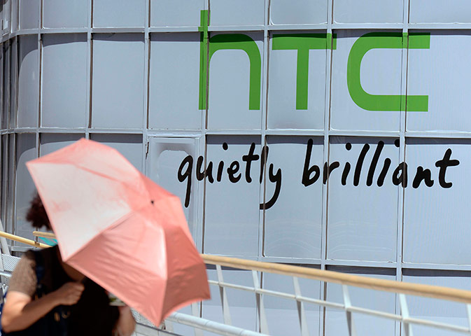 Week in Business: A woman walks past the logo for Taiwan's HTC