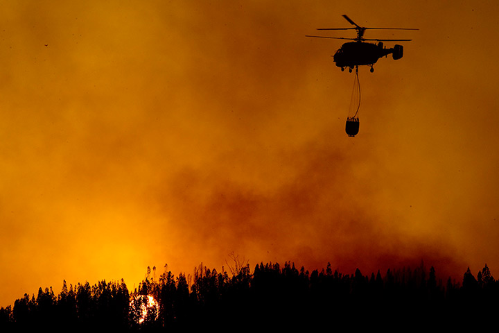 24 hours in pictures: A helicopter fights the flames during a forest near Figuero dos Vinhos