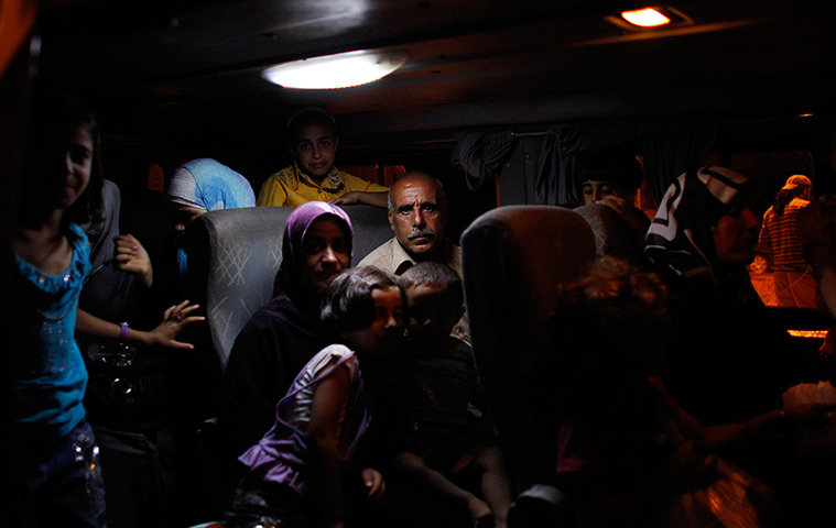 24 hours in pictures: A Syrian refugee family leaves a stopover facility on a bus