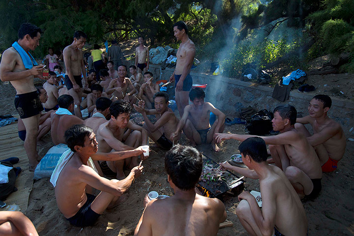 24 hours: A group of men enjoy a barbecue under a tree in North Korea