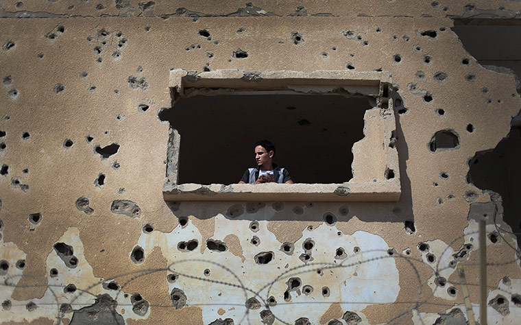 24 hours : A Palestinian man looks out from a destroyed house