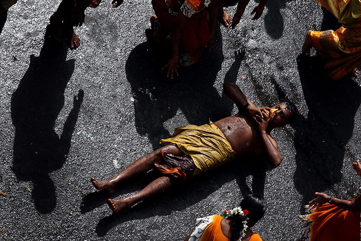 24 hours : A devout Hindu holds a coconut as an offering as he rolls along the ground