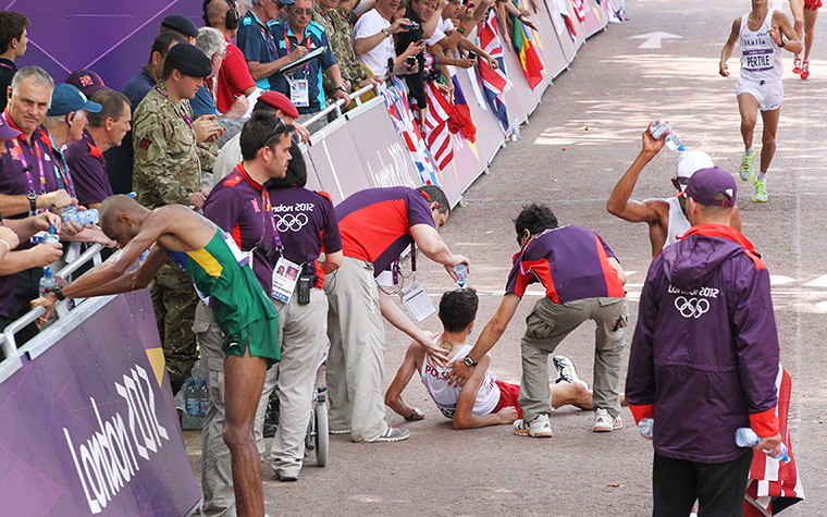 2012 olympic marathon: Exhausted athletes are assisted at the finish line