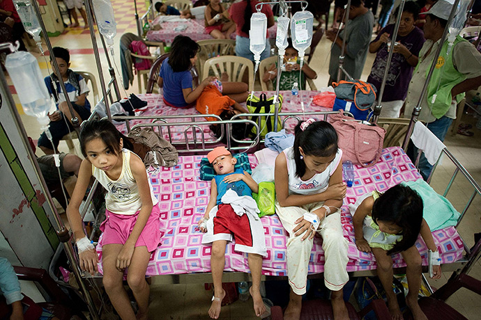 24 hours in pictures: Children with dengue disease share a bed at the Quirino hospital