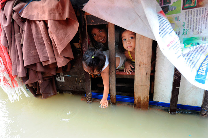 Manila flooding: A child plays with floodwater as childre