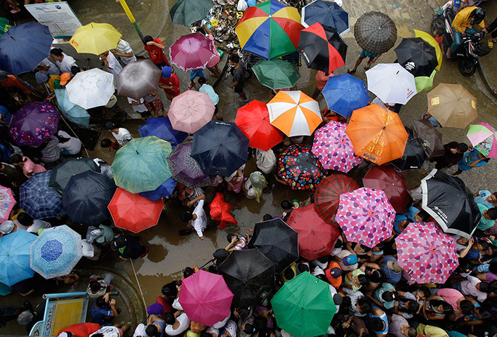 Manila flooding: Flood affected residents gather under the rain