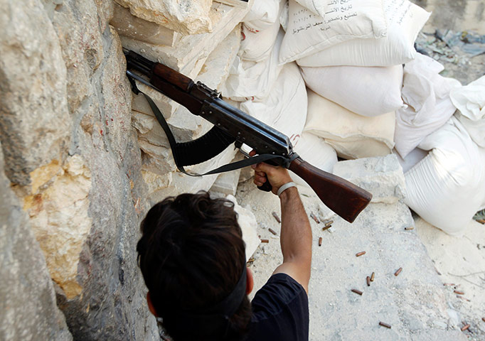 Syrian Conflict: Syrian Conflict: A Free Syrian Army fighter fires an AK-47 rifle in Aleppo