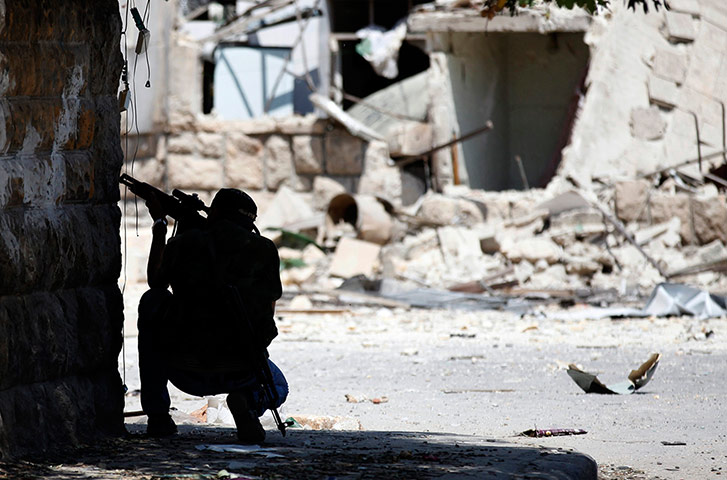 Syrian Conflict: A Free Syrian Army fighter aims his sniper rifle Aleppo