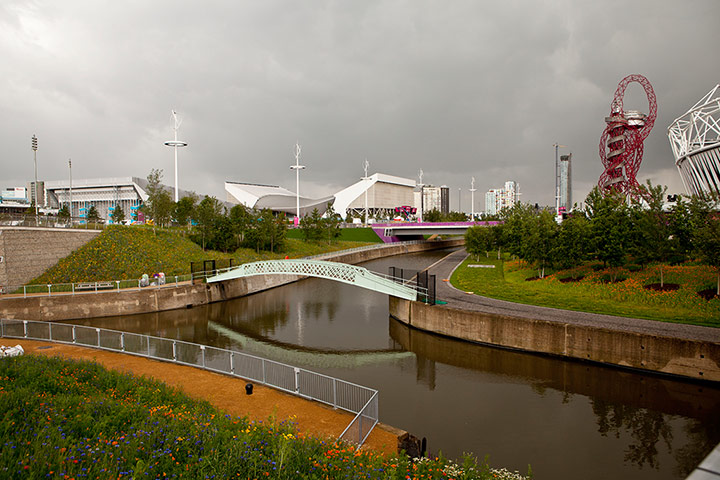London Legacy: Photograph showing an iron bridge over canal with Olympic Orbit behind