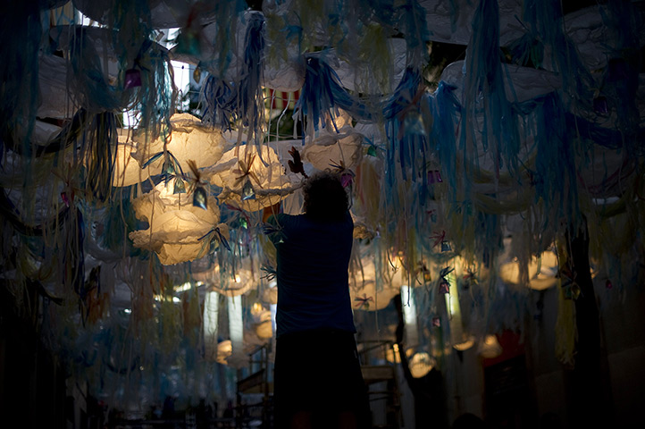 24 hours in pictures: A resident decorates a street during a local festival