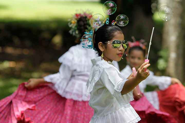24 hours in pictures: A girl in traditional costume plays with bubbles in Panama
