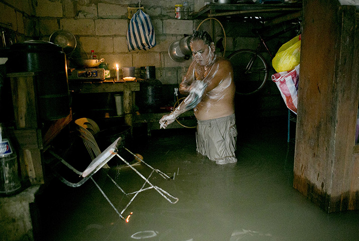 24 hours in pictures: ntonio Navarro Sambiilay  bathes inside his flooded home