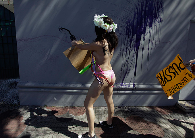 24 hours in pictures: A topless FEMEN activist squirts ink on the wall
