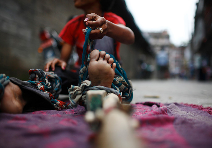 24 hours in pictures: Drumpal Choudhary, 11, a street performer ties his legs with a wooden pole