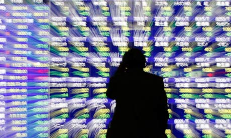 Man looks at a stock quotation board 