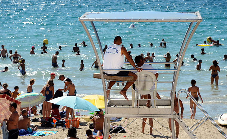 24 hours in pictures: Lifeguards watch people bathing at the C