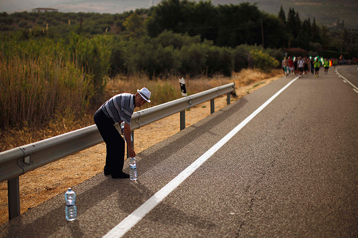 24 hours: Jaen, Spain: An organiser places bottles of water for people on a march