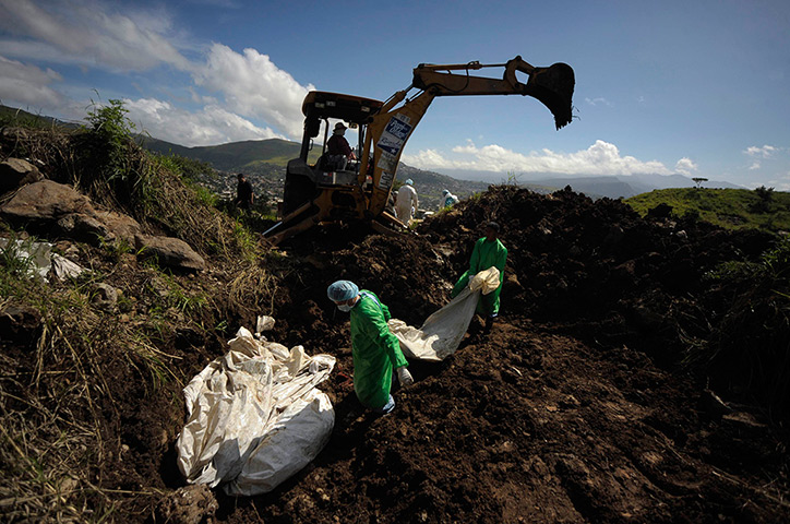 24 hours: Tegucigalpa, Honduras: Morgue workers carry a bag containing a body