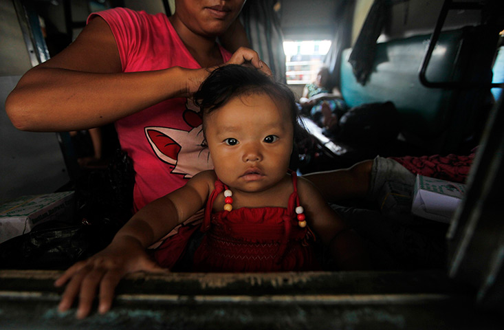 24 hours: Kolkata, India: A woman from northeastern states ties her child's hair