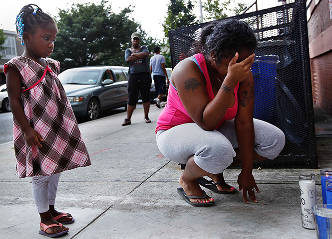 24 hours: Brooklyn, New York, USA: Jennifer Saravia grieves next to a memorial
