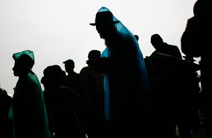 24 hours: East Rutherford, USA:  Orthodox Jews in rain ponchos at Siyum HaShas