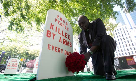 A campaigner lays flowers in a mock graveyard next to the UN building in New York