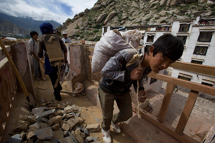 24 hours: Lhasa city, China's Tibet: A Tibetan worker carries stones