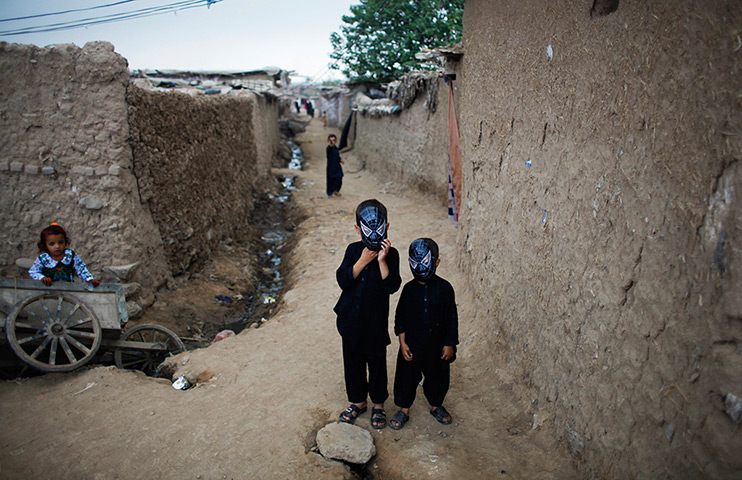 24 hours: Islamabad, Pakistan: Afghan refugee boys wear masks for Eid al-Fitr