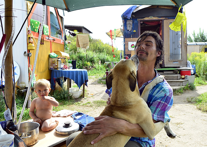 Wagenburg settlement: Malou plays with a cooking pot while her father plays with his dog Digga 
