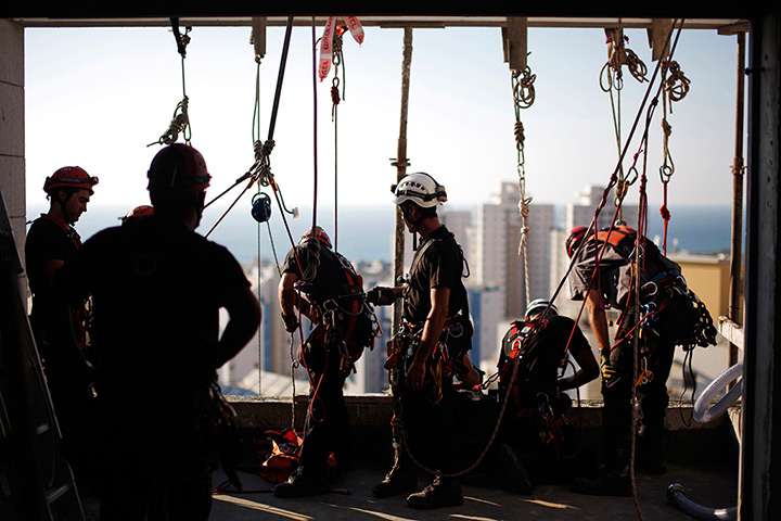 24 hours in pictures: Israeli firefighters prepare their gear before rappelling from a building