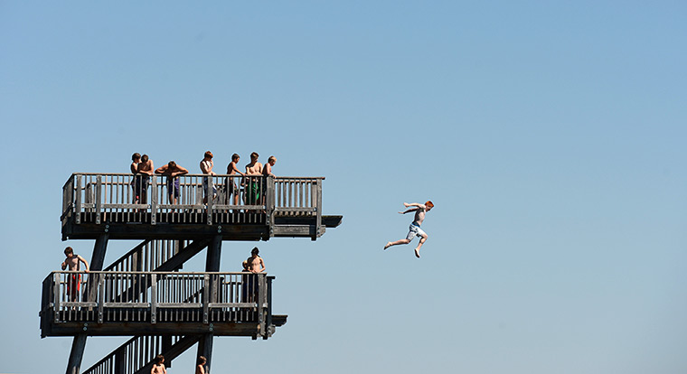 24 hours in pictures: A boy jumps from the diving platform of the lido at the lake Ammersee