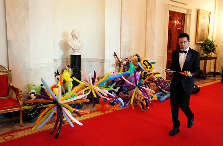 24 hours in pictures: A waiter carries desserts past balloons for attendees at the White House