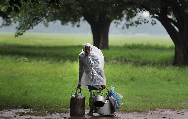 24 hours: Kolkata, India: A tea vendor waits for customers in the rain
