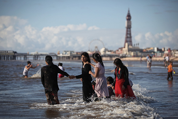 24 hours: Blackpool, England: A family play in the sea