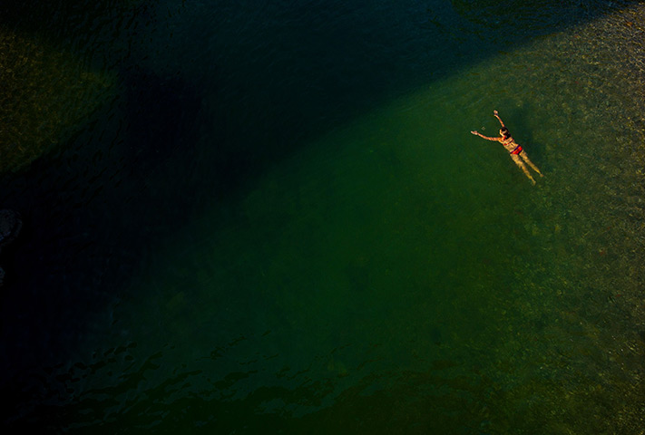 24 hours: Munich, Germany: A woman swims in the Isar river 
