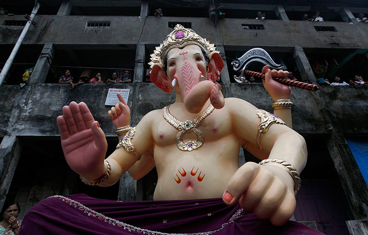 24 hours: Mumbai, India: People look at an idol of Hindu elephant-headed god Ganesh
