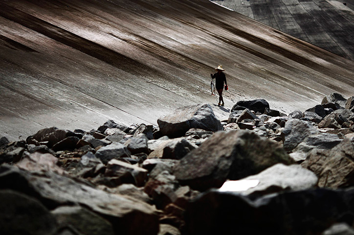 24 hours: Yichang, China: A fisherman walks with his catch