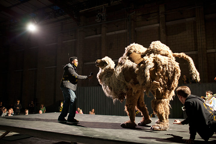 Mittwoch aus Licht: A performer addressing a pantomime camel with a microphone